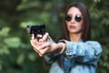 Girl shooting instructor with a gun in his hand aiming at the target