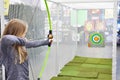 Girl shoots bow in children`s shooting range