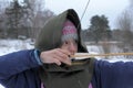 A girl shoots in the winter from a bow at the festival of medieval Vikings