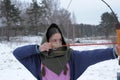 A girl shoots in the winter from a bow at the festival of medieval Vikings