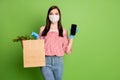 Girl shopper buyer hold paper bag grocery purchase herbs smartphone recommend online delivery wear medical mask blue Royalty Free Stock Photo