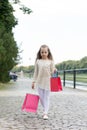 Girl shopping on calm face carries bags, urban background. Kid girl with long hair fond of shopping. Fashionista girl Royalty Free Stock Photo