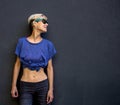 A girl with short hair stands against a dark gray wall Royalty Free Stock Photo