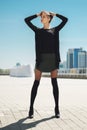 Girl in short leather skirt and legs with knee socks on top of tights enjoys the sun with hands behind the head Royalty Free Stock Photo