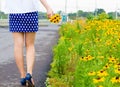 Girl with short skirt walks in the flower garden Royalty Free Stock Photo