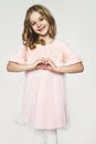 Girl show the heart with her hands. Portrait of cute europeoid blonde girl in pink dress. Beatiful c Royalty Free Stock Photo