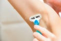 The girl in the shower shaves her armpits with a shaving machine Royalty Free Stock Photo