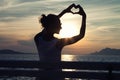 Girl showing heart on sky. Royalty Free Stock Photo