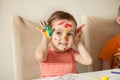 Girl showing painted hands. Hands painted in colorful paints. Education, school, art and painitng concept Royalty Free Stock Photo