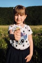 Girl shows bouquet of flowers that she holds in her hand. Small five year old Caucasian girl with beautiful long hair stands at Royalty Free Stock Photo