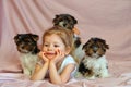 The girl shows the class and lies on her stomach with three puppies. Child dogs. Royalty Free Stock Photo