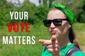 Girl shows a finger and looks at the camera Your Vote Matters text sign. Vote elections.Political choice, use your voice Royalty Free Stock Photo