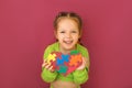 Girl shows heart from puzzle - a symbol of support for kids with autism syndrome Royalty Free Stock Photo