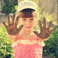 Girl shows her dirty hands. Toned image