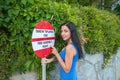 The girl shows on the road sign, indicates the direction of the path