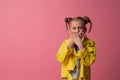 Girl shut her mouth with her hands in yellow clothes on pink background. concept of silence