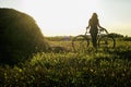 girl silhouette sitting on bicycle in a sunny summer field at sunset Royalty Free Stock Photo