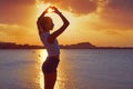 Girl silhouette at beach sunset heart shape Royalty Free Stock Photo