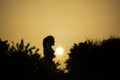 Girl silhouette watching the sun at sunset at Sounion