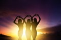 girl silhouettes hands making heart shape with sunset background Royalty Free Stock Photo