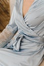 A girl in a silk robe meets morning. Woman unties the ties of a blue robe. Girl in silk underwear Royalty Free Stock Photo