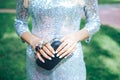 Girl in a silver dress with a small black handbag brass knuckles . Fashion Clothes Accessories Set. brass knuckles