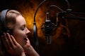 Girl singer sings into a microphone, with a spectacular background, vocals, recording studio, recording a track Royalty Free Stock Photo