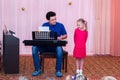 Girl sings while her father plays synthesizer