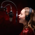 Girl sings into a studio microphone in a recording studio. Square photo for instagram Royalty Free Stock Photo