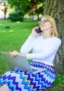 Girl sit grass with notebook. Woman with laptop in park order item on phone. Girl takes advantage of online shopping Royalty Free Stock Photo