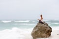 Girl sit at the seaside on the rock and meditating in yoga pose Royalty Free Stock Photo