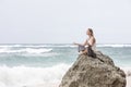 Girl sit at the seaside on the rock and meditating in yoga woman pose Royalty Free Stock Photo