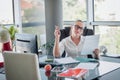 Girl siting in an office chair and checking contracts and documents. Office worker. Business woman.