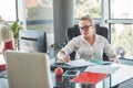 Girl siting in an office chair and checking contracts and documents. Office worker. Business woman.