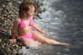 Girl sits ashore in waves Royalty Free Stock Photo