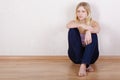 Girl sits with back pressed against wall Royalty Free Stock Photo