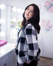 Girl sits on a bar stool in a plaid jacket Royalty Free Stock Photo