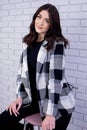 Girl sits on a bar stool in a plaid jacket Royalty Free Stock Photo