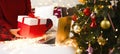 A girl sits on a bed with a large Christmas present in her hands in front of the laptop. Royalty Free Stock Photo