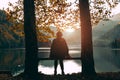 A girl sits on a bench and looks at Lake Ritsa at sunset in Abkhazia. Beautiful Mountain landscape