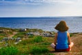 Girl sits on the coast and looks at the sea. Royalty Free Stock Photo