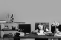 Girl sits at desk with books, flowers, fruit and blackboard Royalty Free Stock Photo