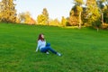 the girl sits on the field and the wind blows her hair Royalty Free Stock Photo