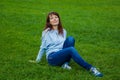 the girl sits on the field and the wind blows her hair Royalty Free Stock Photo