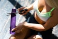 Girl sits on the floor and cuts purple kinesio tape with scissors. View from above