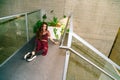 Girl sits on floor near pot with green plants