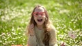 Girl sits on grass at grassplot, green background. Child girl spend leisure outdoors. Best holiday concept. Child posing