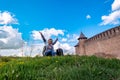 A girl sits on the grass near the Khotyn fortress in Kamenetz-Podolsk Royalty Free Stock Photo