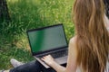 girl sits on the grass and works at a laptop. freelance. selfeducation. the concept of distance learning outdoors.