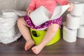 The girl sits on a green pot and learns elementary hygiene, switching from diapers to a toilet Royalty Free Stock Photo